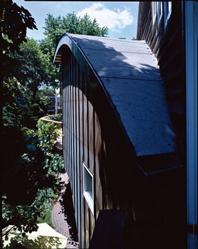 
Emphasizing flow, the copper-clad stairway is crowned by an arched roof. The curved main deck juts out just beyond.

